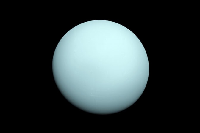 Uranus appears as a sky blue sphere in the black void of space.