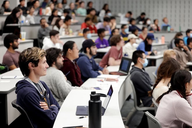 Students in a lecture hall listening to a professor