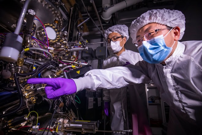 Two researchers in the lab pointing at results