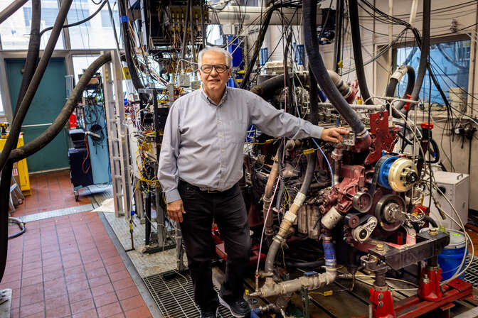 Andre Boehman posing in front of mechanical engineering laboratory equipment.