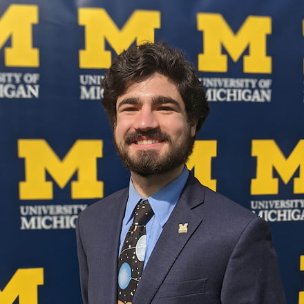 Portrait Connor Todd with M logo background.