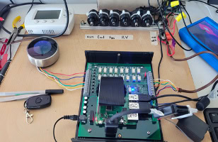 A desktop setup with a circuit board, colorful wires, digital display, and labeled components.