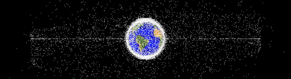 A computer-generated image of the objects, including debris or satellites surrounding Earth in outer space. s. The debris forms a dense spherical halo around the planet, with some concentration along the equator and extending further into space.