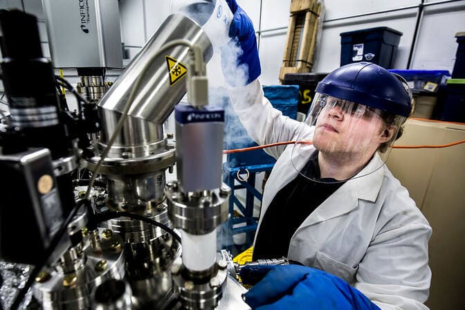 A student wearing full personal protective equipment working on equipment in the Michigan Ion Beam Laboratory.