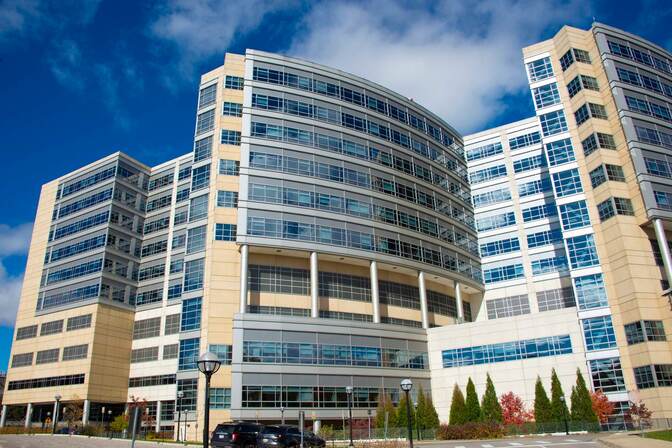 The Michigan Medical Campus building, featuring multiple stories and stone facade.