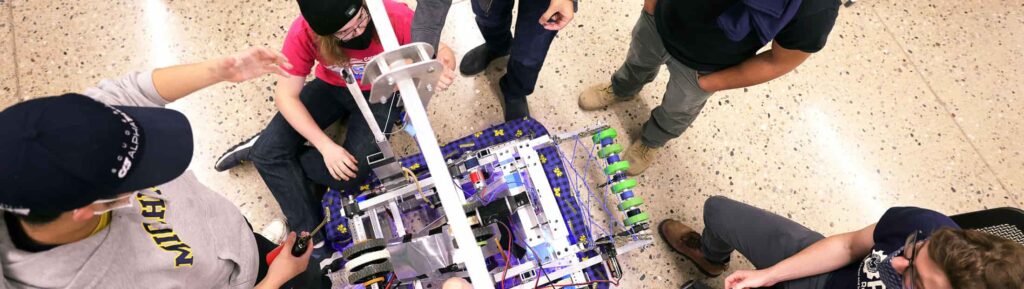 Overhead shot of students working around a robot