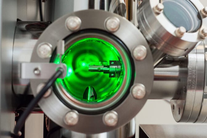 Close-up view of a scientific instrument with a green-lit interior chamber.