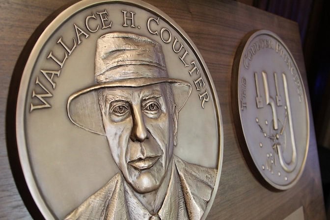 A close-up of a circular bronze plaque of Wallace H. Coulter , with his face and name engraved on it.