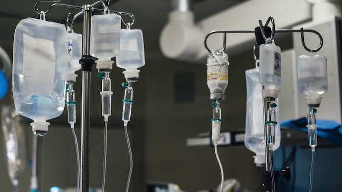 Several IV fluid bags hanging from metal stands.