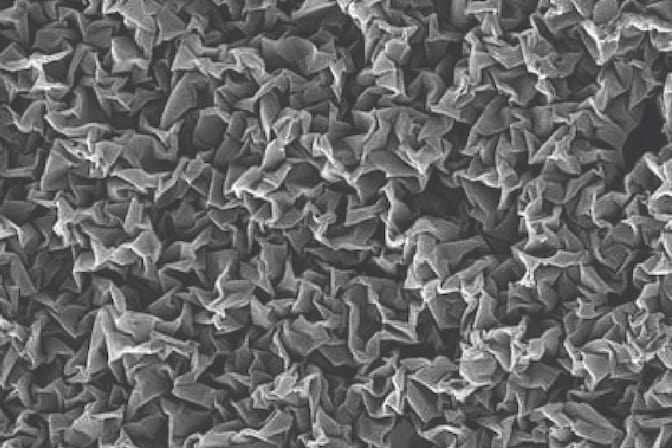 A close-up of the nano-crumpled coating shows greyscale ridges and valleys.