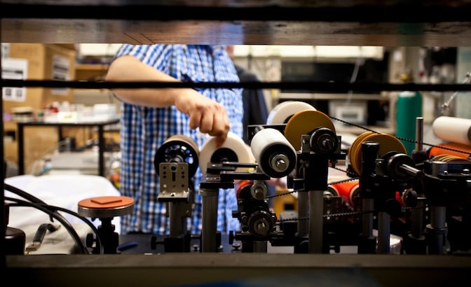 Six different rolling elements are pictured, assembled into a system on a lab bench. Some rollers resemble rolling pins while others resemble wheels.