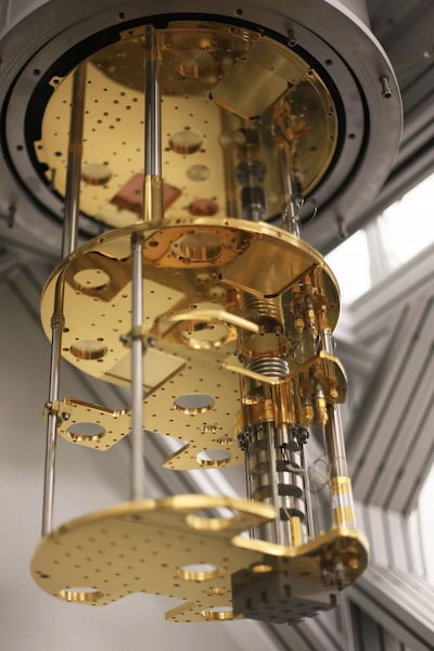 The inside of the dilution refrigerator looks like three golden discs connected by metal rods, with a thicker cylinder of black and silver elements running down one side.