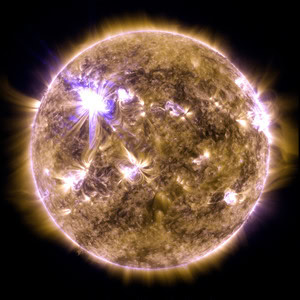 The sun looks like a fiery yellow ball with flashes and loops of blue and white light.