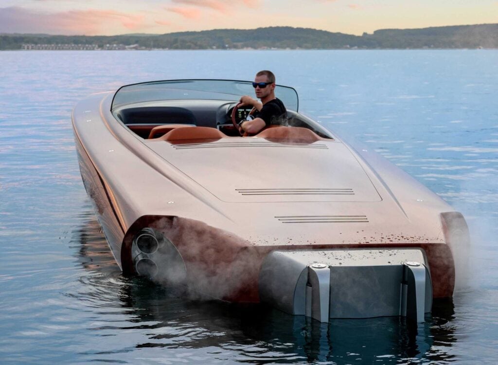  Ben Van Dam sits at the helm of a powerful motorboat floating on a lake. 