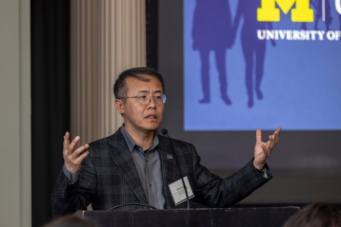 Henry Liu stands at a podium and presents.