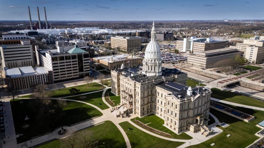 An aerial view of the Michigan State Capitol building and surrounding city in Lansing on a clear day.