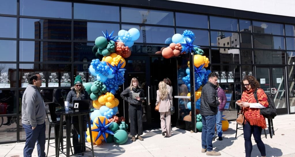 Attendees gather outside an industrial-style venue during an event.