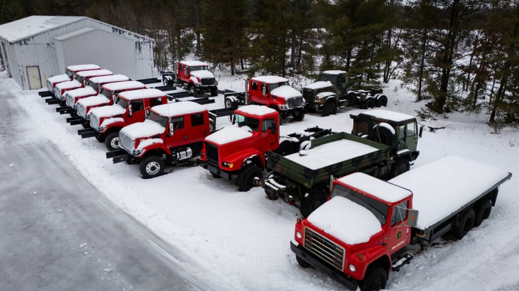 An aerial view of firefighting trucks on a snow-covered ground.