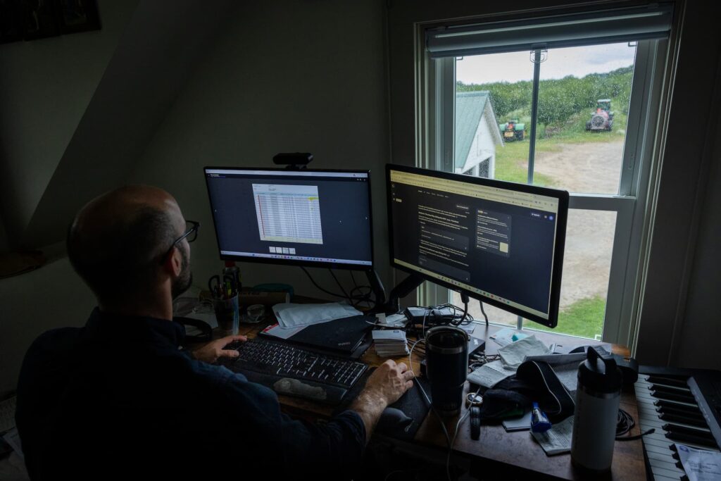 Chris Lyon works at his computer in a home office overlooking the farm.