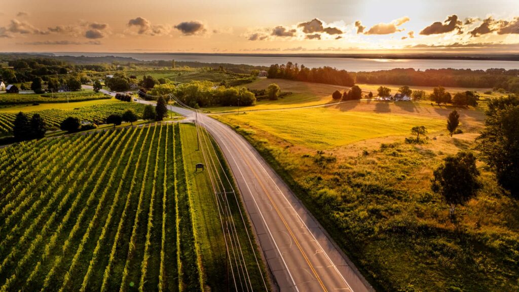 Rows of vineyards and meadows stretch across Old Mission Peninsula with Grand Traverse Bay in the background.