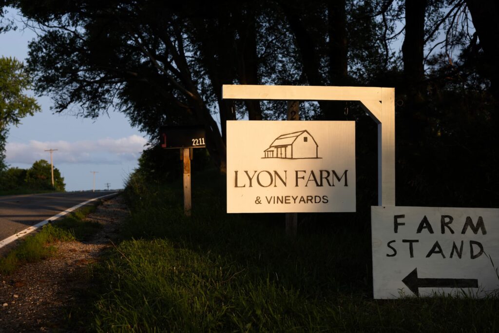 Entrance sign for Lyon Farm & Vineyards beside the roadside farm stand on Old Mission Peninsula.