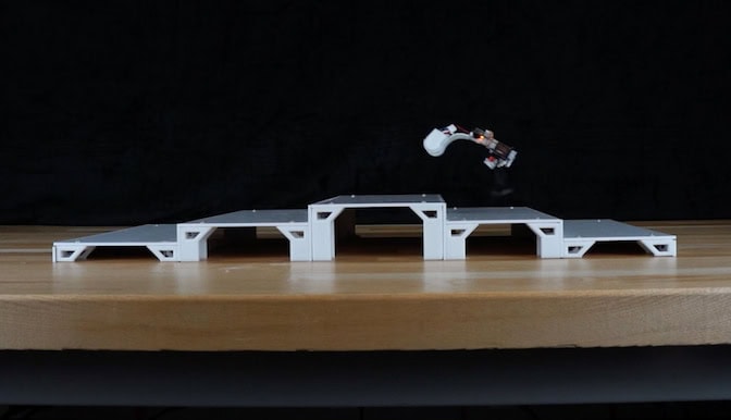 he five stairs, ascending and then descending, are scaled to the size of the robot—about one body-length for tread depth and half the robot's height for rise. The robot is in midair above the second step.